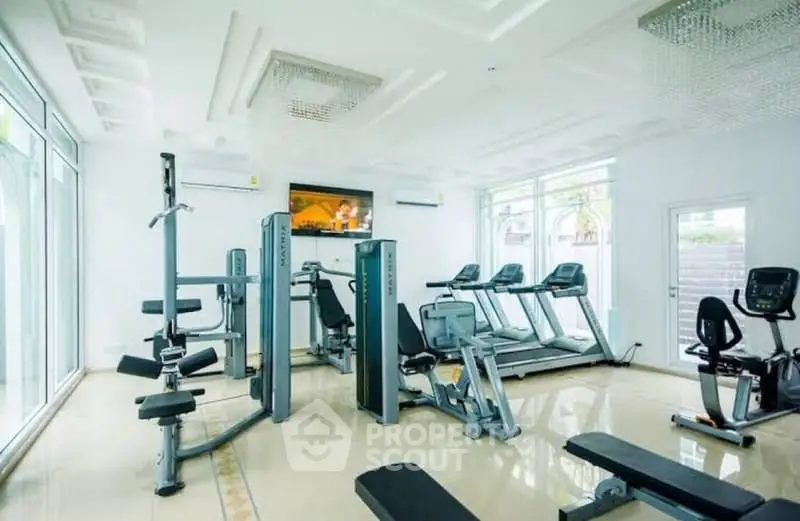 Modern gym with state-of-the-art equipment and bright natural lighting.