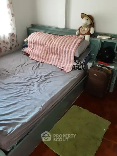 Cozy bedroom with plush toys and suitcase, perfect for a comfortable stay.