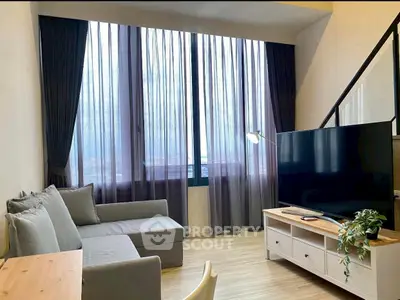 Modern living room with large windows and stylish furniture, perfect for relaxation and entertainment.