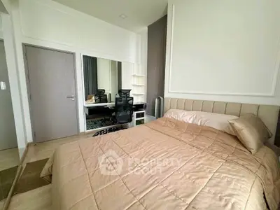 Modern bedroom with stylish decor and workspace, featuring a comfortable bed and sleek furniture.