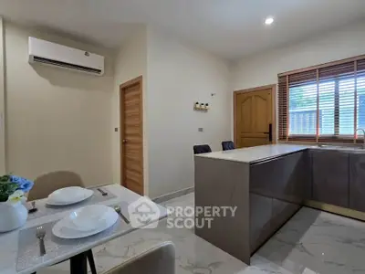 Modern kitchen with sleek design, featuring an open layout and elegant dining area.