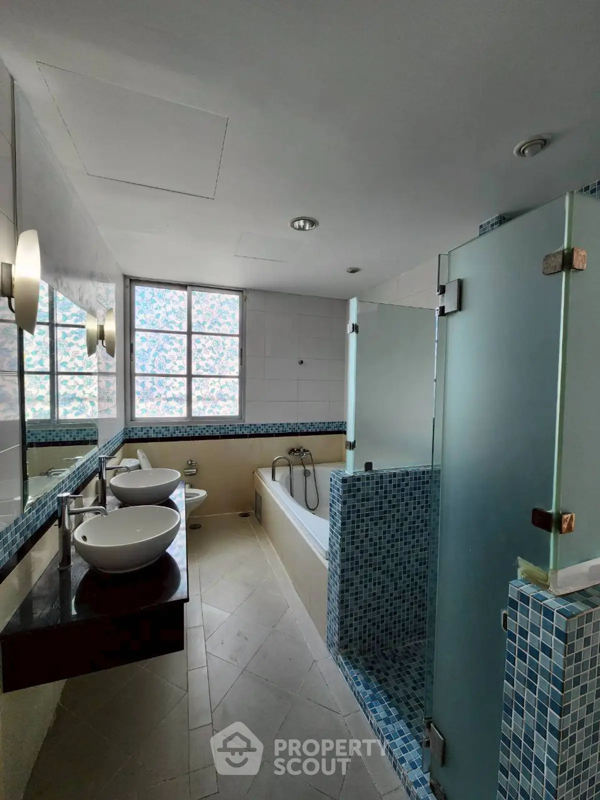 Spacious modern bathroom with dual sinks and glass shower enclosure
