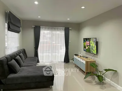 Modern living room with sleek furniture and large windows for natural light.
