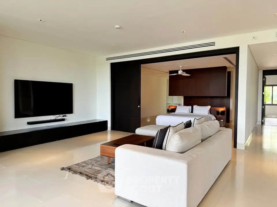 Luxurious open-plan living room with modern decor and sleek TV setup
