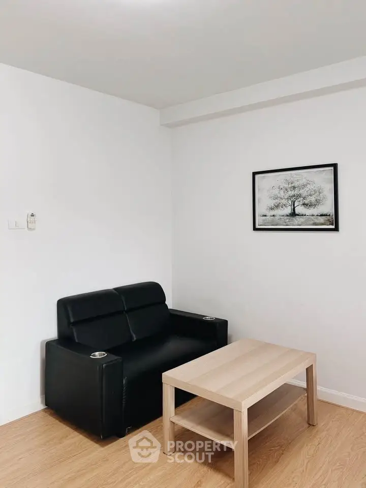 Modern minimalist living room with black sofa and wooden coffee table