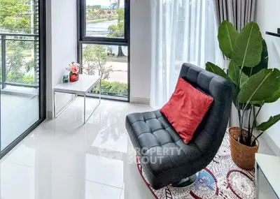 Modern living room with large windows and stylish furniture overlooking a scenic view.