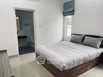 Modern bedroom with ensuite bathroom, featuring sleek design and natural light.