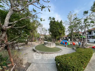 Charming residential garden with lush greenery and play area, perfect for family living.