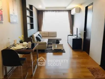 Modern living room with stylish decor and natural light, featuring a cozy sofa and dining area.