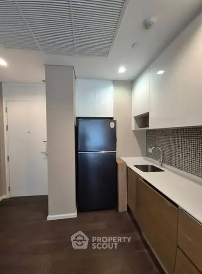 Modern kitchen with sleek cabinetry and dark wood flooring