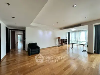 Spacious empty living room with wooden flooring and large windows