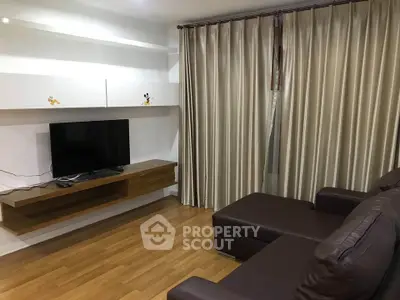 Modern living room with sleek TV setup and elegant curtains, perfect for cozy relaxation.
