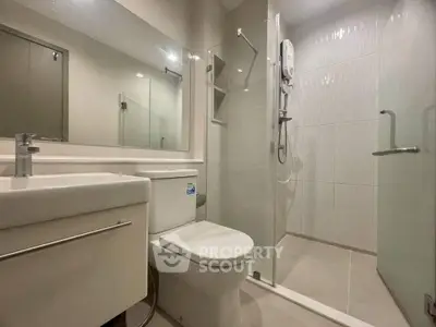 Modern bathroom with glass shower and sleek fixtures in a contemporary apartment.