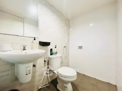 Modern bathroom with sleek fixtures and minimalist design, featuring a wall-mounted sink and toilet.