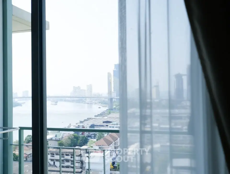 Stunning cityscape view from a high-rise balcony with river and skyline.