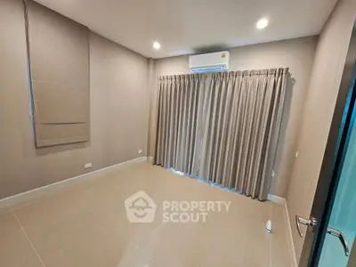 Spacious unfurnished room with air conditioning and elegant curtains, perfect for customization.