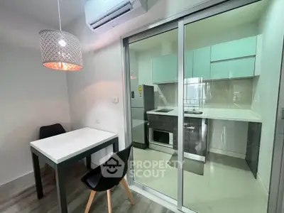 Modern kitchen with sleek design, featuring a dining area and glass sliding doors for a spacious feel.