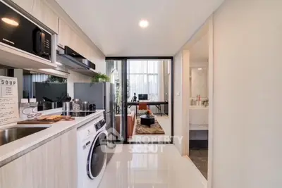 Modern kitchen with washing machine and open layout leading to stylish living area