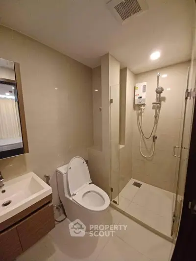 Modern bathroom with glass shower and sleek fixtures in a contemporary apartment.