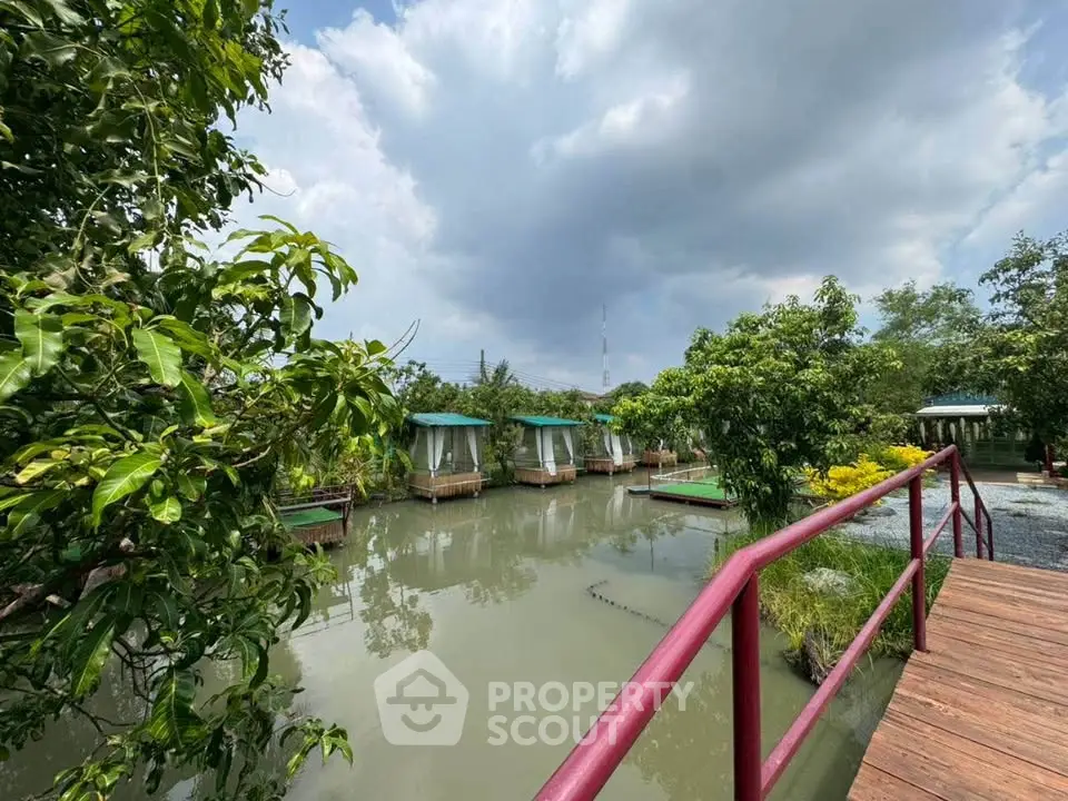 Scenic view of waterfront cabins surrounded by lush greenery and a serene pond, perfect for tranquil living.