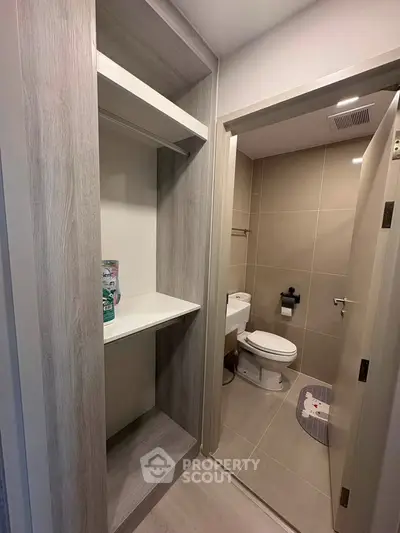 Modern bathroom with sleek design and built-in storage, featuring neutral tones and contemporary fixtures.