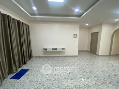 Spacious unfurnished living room with modern tile flooring and elegant ceiling design