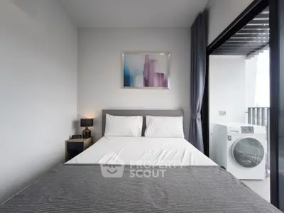 Modern bedroom with balcony and washing machine, featuring stylish decor and natural light.