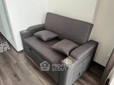 Modern compact living room with stylish gray sofa and wooden flooring