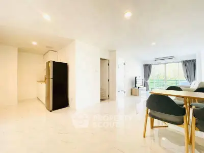 Spacious open-plan living room with modern dining area and natural light.