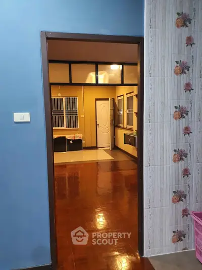Charming interior view showcasing polished wooden floors and floral wall tiles, perfect for cozy living.