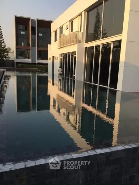 Modern luxury building with sleek pool reflecting architecture