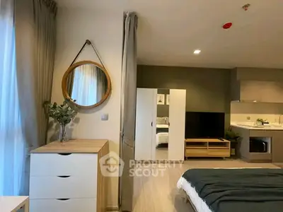 Modern studio apartment with stylish decor and open layout, featuring a cozy bed, sleek kitchen, and elegant furnishings.