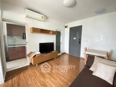 Modern living room with wooden flooring and sleek furniture in a cozy apartment.