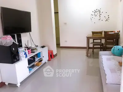 Cozy living room with modern TV setup and dining area, perfect for relaxation and entertainment.