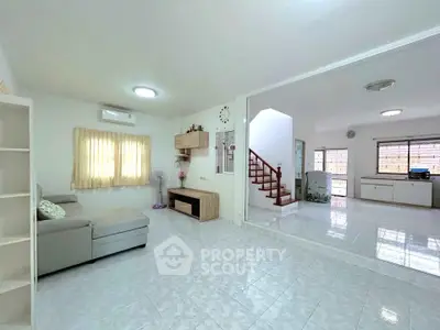 Spacious living room with modern decor and open layout, featuring a cozy sofa and stylish shelving.