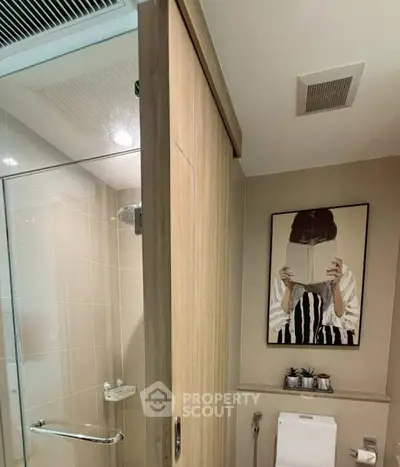 Modern bathroom with glass shower and stylish wall art