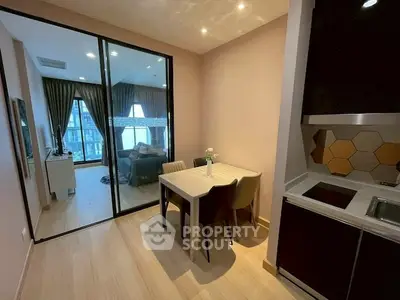 Modern open-plan kitchen and dining area with glass partition to living room.