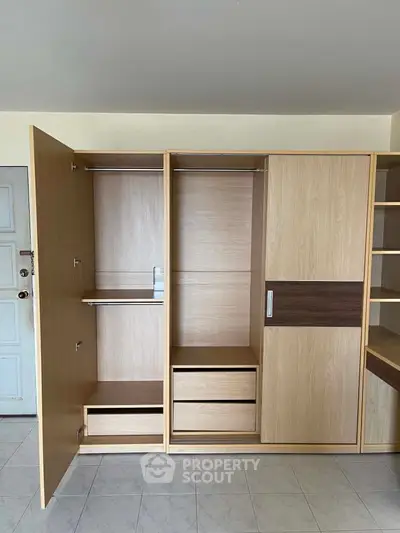 Spacious wooden wardrobe with open shelves and drawers in modern apartment