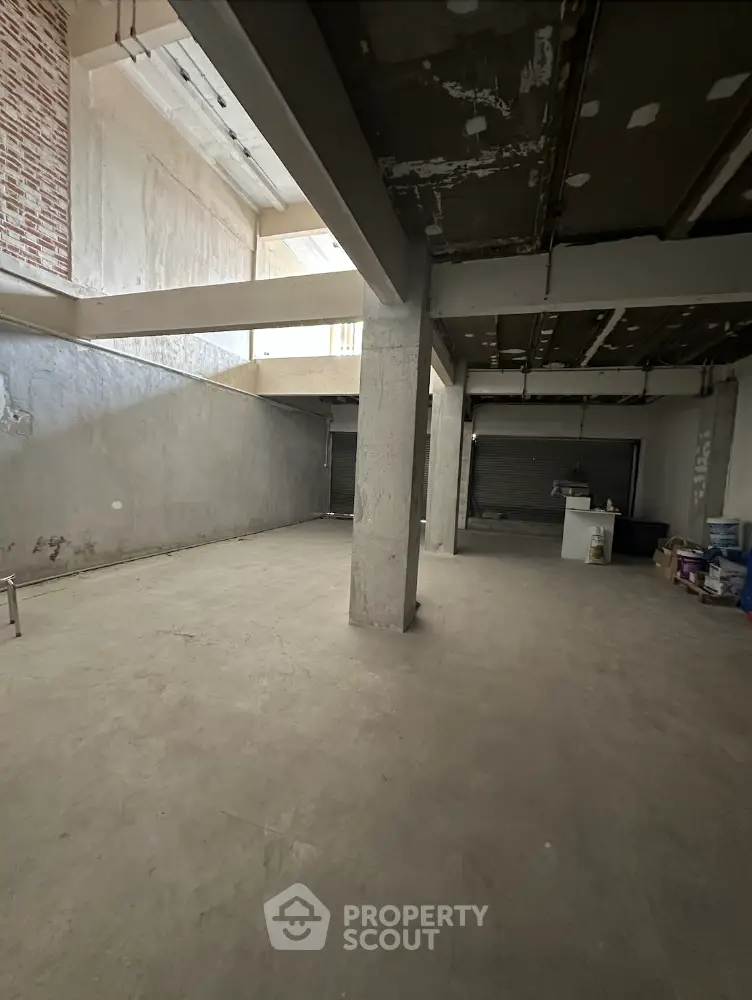 Spacious industrial-style open space with high ceilings and exposed beams, ideal for creative projects.