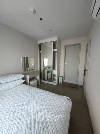 Modern bedroom with minimalist design and ample natural light.