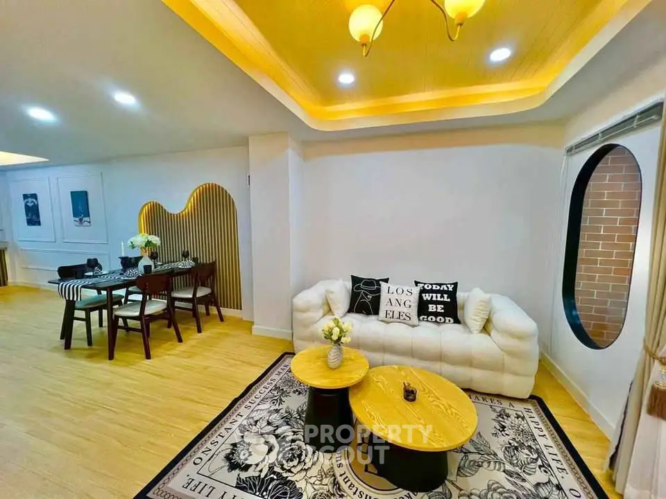 Stylish modern living room with cozy seating and elegant dining area, featuring unique lighting and decor.
