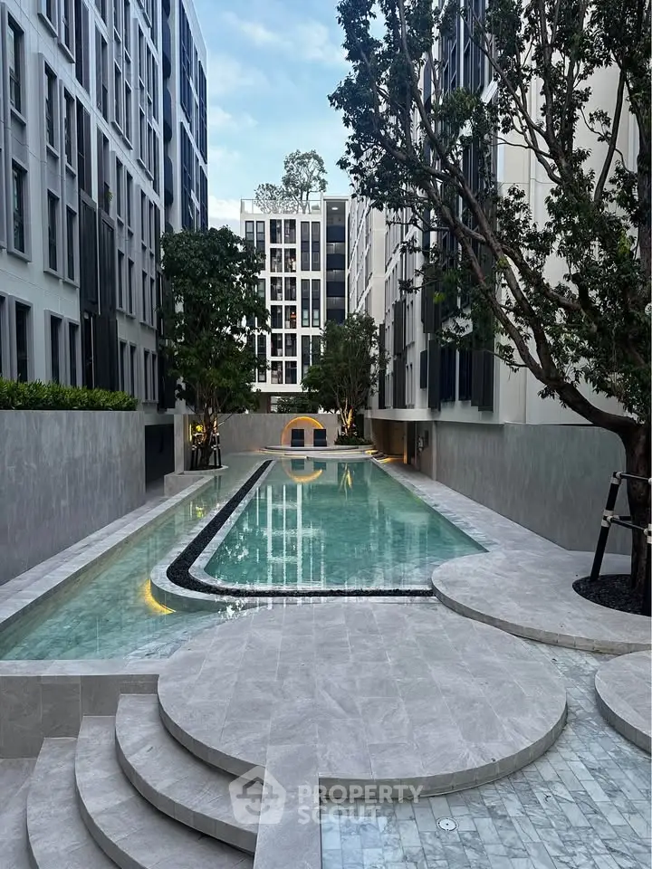 Luxurious modern apartment complex with stunning pool and elegant design.