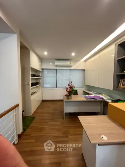 Modern study room with wooden flooring and built-in shelves