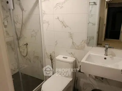 Modern bathroom with marble tiles and glass shower enclosure