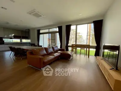 Spacious modern living room with large windows and stylish furniture, perfect for relaxation and entertainment.