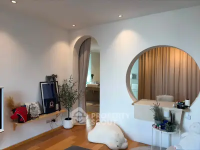 Modern living room with unique circular mirror and cozy decor