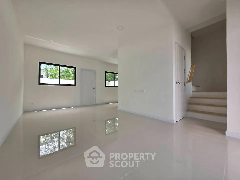 Spacious modern living room with glossy tile flooring and natural light.