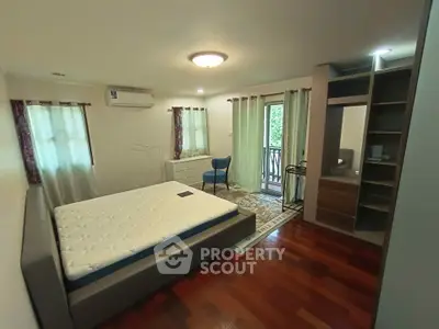 Spacious bedroom with balcony access and wooden flooring