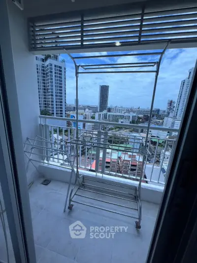 High-rise balcony with cityscape view and drying rack, perfect for urban living.