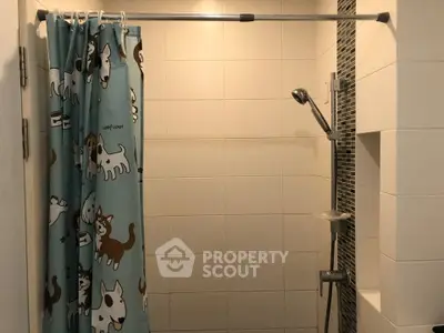 Charming bathroom with playful dog-themed shower curtain and modern shower fixtures.